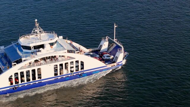 Vehicle ferry underway with cars parked on deck. Short sea crossing for passenger and automobile transportation