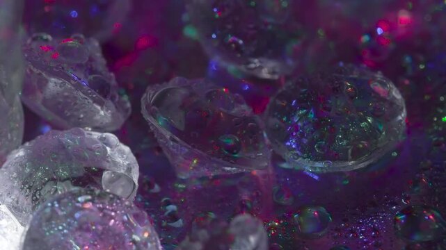 Process of Natural Diamond Treatment. Small crystals with a classic cut on a mirror surface slowly move in front of the camera, shimmering in the laser beams