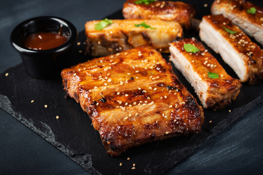 Barbecue pork spare ribs with hot honey chili marinade on black background