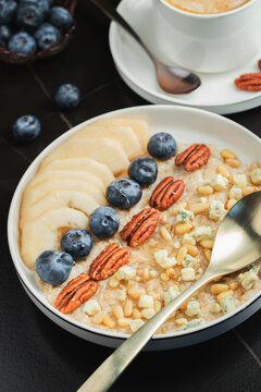 Oatmeal. Bowl of oatmeal porridge with blackberry, bananas and chia seeds on gray concrete old table background. Top view in flat lay style. Natural ingredients. Hot healthy breakfast and diet food