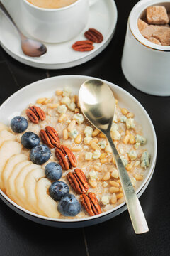 Oatmeal. Bowl of oatmeal porridge with blackberry, bananas and chia seeds on gray concrete old table background. Top view in flat lay style. Natural ingredients. Hot healthy breakfast and diet food