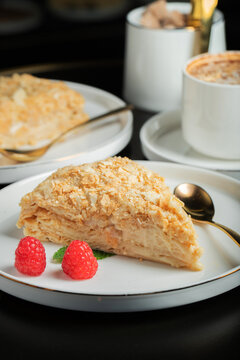 Sliced Napoleon cake on a white wooden table. Classic dessert