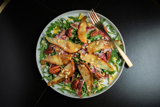 Salad with Pear, Arugula, Jamon, Blue Cheese and Blueberry, Delicious Fresh Salad Appetizer on Bright Background