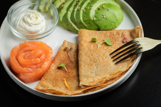 Roasted thin pancakes with smoked salmon and sauce