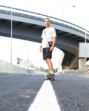 Young Man Riding Longboard on Road in Slow Motion
