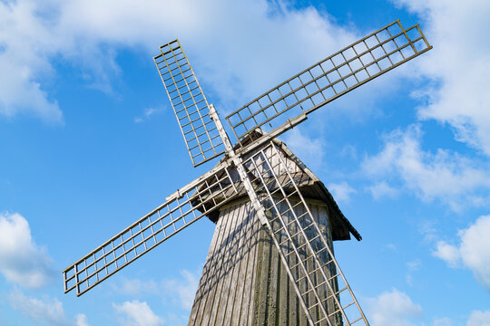 Wings of an old wooden windmill against a blue sky. Mikhailovskoye, Pushkinskie Gory. Pskov region, Russia