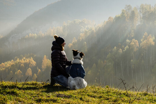happy woman having fun with her dog in autumn
