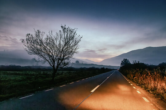 car traveling on road at dusk