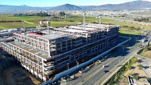 Aerial drone view of hospital construction site with access road and parked vehicles Keywords extra: road, traffic, vehicles, parking, panorama, low angle, daylight