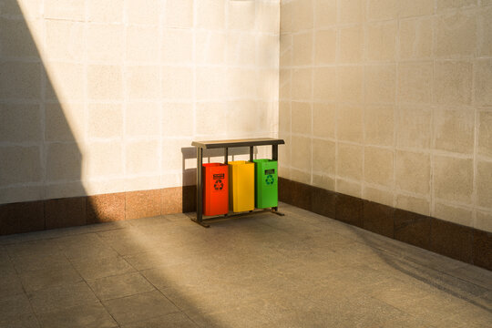 Recycling Bins Stand in a Corner in Sunset Light