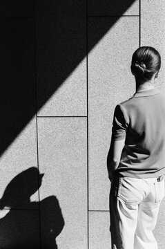 The young woman strolls through a city park on a sunny day. 


