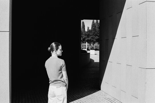 The young woman strolls through a city park on a sunny day. 

