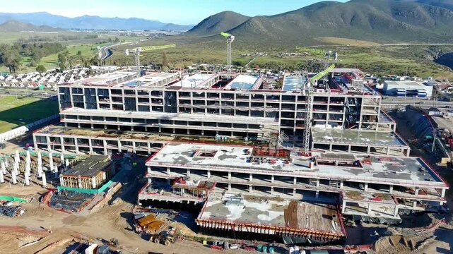 Aerial view of hospital building frame with exposed rebar and scaffolding Keywords extra: rebar, scaffolding, exposed frame, concrete structure, unfinished building