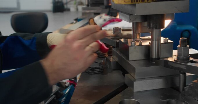 Repeated forming of metal components on industrial stamping equipment. Close-up of a high-volume manufacturing process