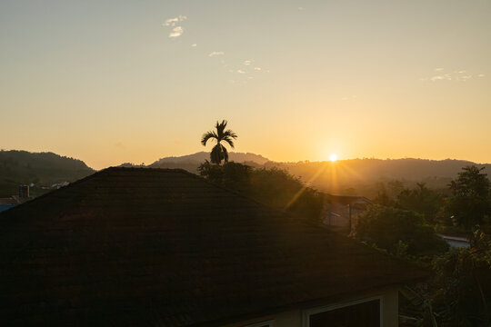 Golden sunset view of tropical resort villas surrounded by mountains
