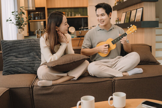 Happy Asian couple enjoying time together in their new home
