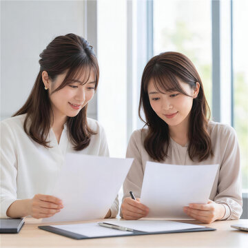 オフィスで書類を照合する日本人女性2人