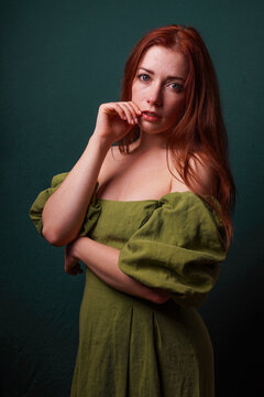 emotive portrait of redhead woman in green vintage off the shoulder dress resembling classical painting
