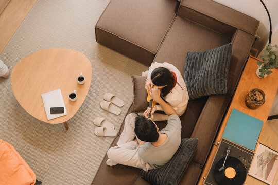 Happy Asian couple enjoying time together in their new home