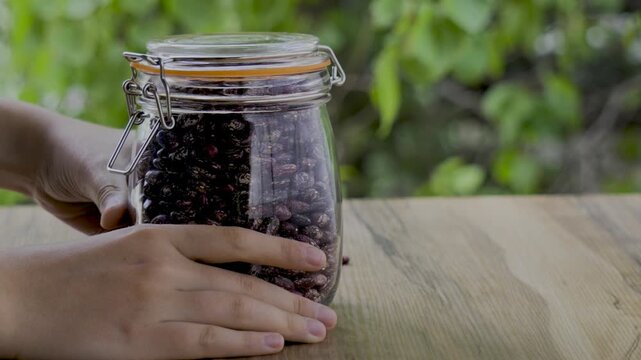 Hand grabbing a pinto beans jar and moving toward camera 4k