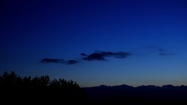 Planets and stars on a twilight countryside sky. Real time video.