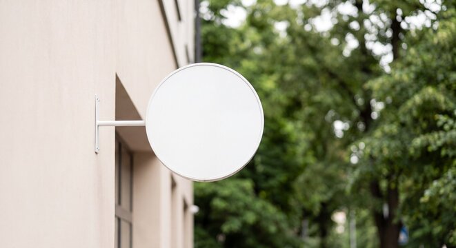 Blank round white signboard mockup mounted on exterior building wall