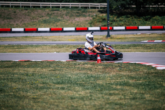 Dynamic shot of a teenager driving a go-kart around a track curve