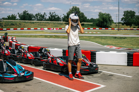 Teenage boy taking off his helmet after finishing a go-kart race