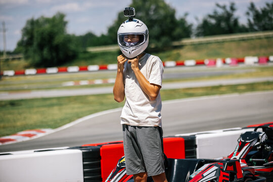 Young driver removing his racing helmet after an outdoor go-kart session