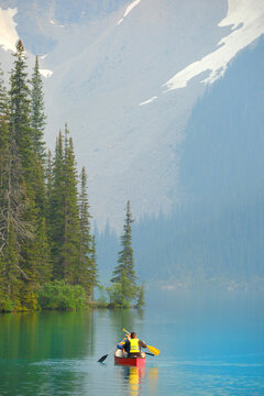 Family in Red Canoe on Pristine High Mountain Lake named Moraine Lake in Banff National Park in Alberta Canada