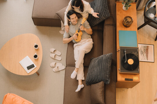 Happy Asian couple enjoying time together in their new home