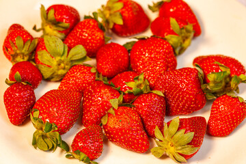 High speed capture of ripe red strawberries suspended in water with dynamic splashes against a dark background. This image conveys freshness, vitality, and healthy food concepts, ideal for culinary,  © Narong Niemhom