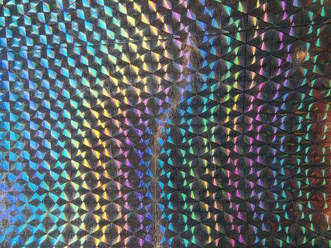 Abstract holographic geometric pattern with rainbow iridescent light reflections and textured surface