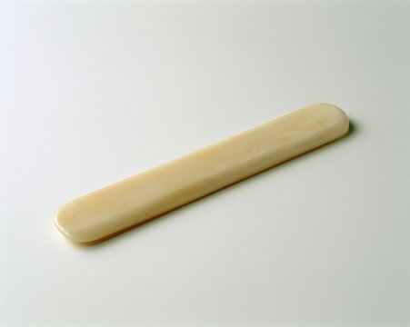 Long, flat, pale yellow object lying horizontally.