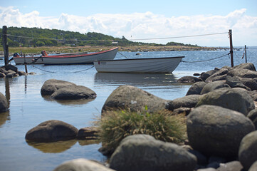 Wooden rowing boats moored beside a stone breakwater © Beata