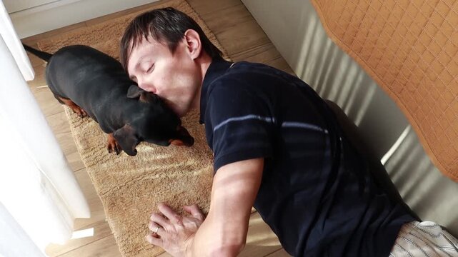 homem recebe amor e carinho de cachorro da ra&ccedil;a duchshund 