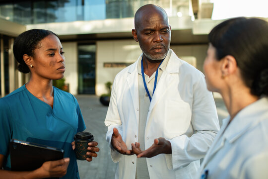 Doctors and nurse discussing case outside hospital