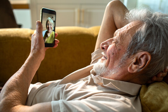 Senior man smiling while video calling on smartphone at home