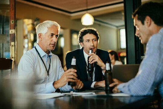 Business colleagues discussing over after-work drinks at a bar