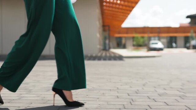 Close up of business woman legs walking on a city street in high heels
