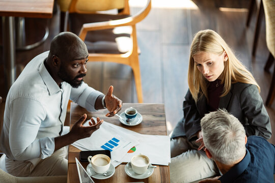 Business team discussing financial report at coffee shop