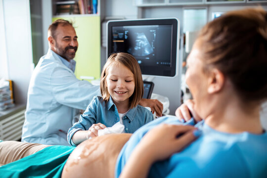 Pregnant mother with child and doctor during prenatal ultrasound in clinic