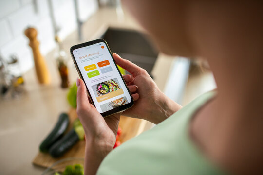 Person using meal planning app in home kitchen