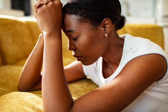 Stressed woman resting head on hands at home