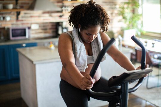 Woman working out on an exercise bike in a home kitchen
