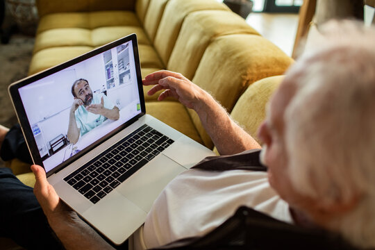 Senior man having online doctor consultation at home