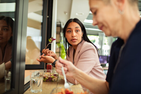 Coworkers having lunch and conversation at a cafe