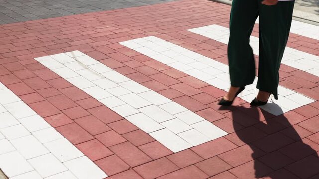 Close up of business woman legs crossing the street on zebra pedestrian walk, slow motion