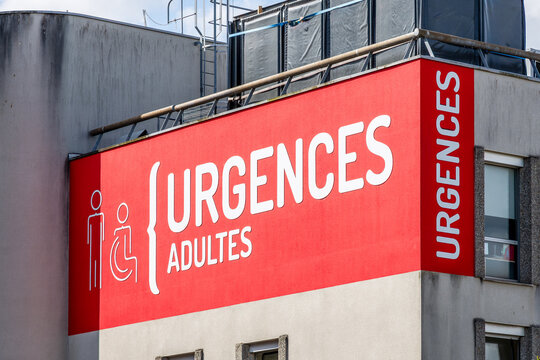 Close-up view of the large emergency service sign at a French hospital ("urgences" in French) in white capital letters on a red background.
