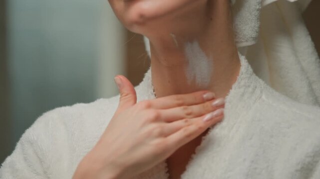 Close up Caucasian adult woman applying moisturizer lifting cream doing massage on neck at beauty procedure in bath middle-aged female skincare routine with anti-wrinkle products cosmetic at home